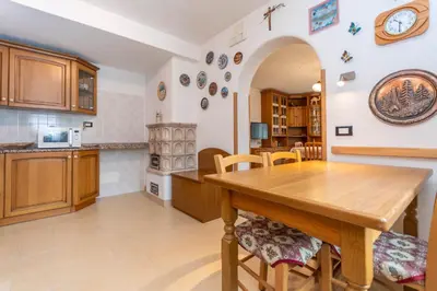 a kitchen and dining room with a wooden table and chairs at Casa Erica in Falcade