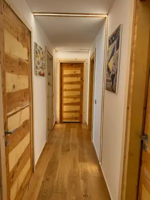 a hallway with wooden floors and a door at Cesa Balzan in Canazei