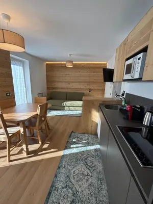 a kitchen and dining room with a table and a couch at Cesa Balzan in Canazei