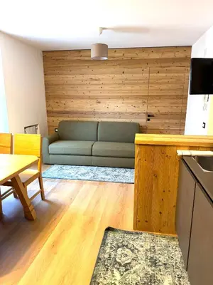 a living room with a green couch and a table at Cesa Balzan in Canazei