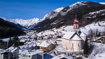 a small town with a church in the snow at Historic Residence Barbara in Colle Isarco