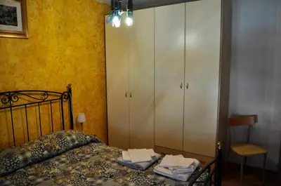 a bedroom with a bed and a cabinet and a chair at Silvano Fanti in Rumo