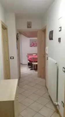 a hallway of a kitchen with a table and a refrigerator at Silvano Fanti in Rumo