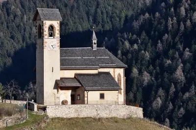 a church on top of a hill with a clock tower at Silvano Fanti in Rumo