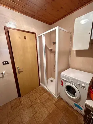 a bedroom with a bed and a door to a balcony at Casa Defrancesco in Panchia