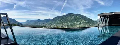 a pool of water with a view of a mountain at SomVita Suites in Tirolo