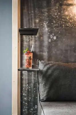 a drink sitting on a shelf next to a window at SomVita Suites in Tirolo