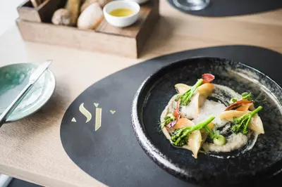 a black plate of food on a table at SomVita Suites in Tirolo