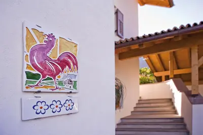 a painting of a rooster on the side of a building at Ferienwohnungen Plonerhof in San Paolo