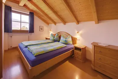 a bedroom with a bed with blue sheets and a window at Ferienwohnungen Plonerhof in San Paolo