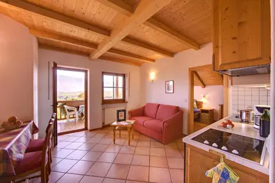 a kitchen and living room with a red couch at Ferienwohnungen Plonerhof in San Paolo