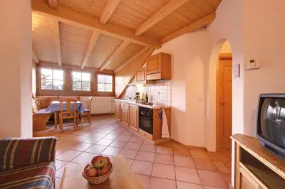 a kitchen and living room with a table and a tv at Ferienwohnungen Plonerhof in San Paolo