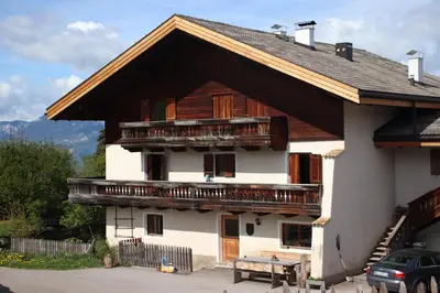 a house with wooden balconies on the side of it at mösslerhof in Aldino