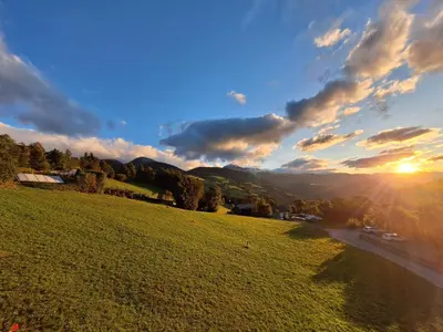 a grassy field with the sun in the sky at Residence Rastbichl - Apartments & Indoor-Pool in Maranza