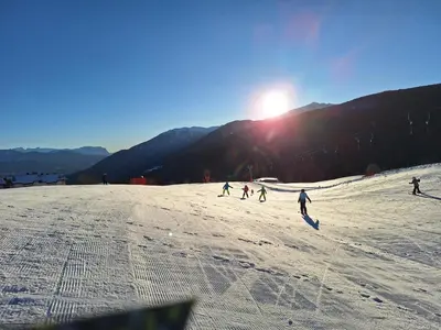 a group of people skiing down a snow covered slope at Residence Rastbichl - Apartments & Indoor-Pool in Maranza