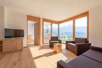 a house on a hill with mountains in the background at Moosbichlerhof in Marlengo