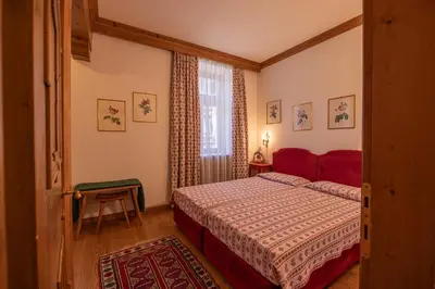 a bedroom with a red bed and a window at Casa Ciclamino, direttamente sul Corso di Cortina dAmpezzo in Cortina dʼAmpezzo