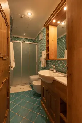 a bathroom with a sink and a toilet and a mirror at Casa Ciclamino, direttamente sul Corso di Cortina dAmpezzo in Cortina dʼAmpezzo