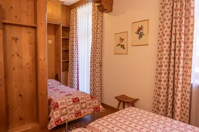 a bedroom with two beds and a window at Casa Ciclamino, direttamente sul Corso di Cortina dAmpezzo in Cortina dʼAmpezzo