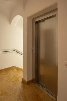 a metal door in a room with a tile floor at Casa Ciclamino, direttamente sul Corso di Cortina dAmpezzo in Cortina dʼAmpezzo