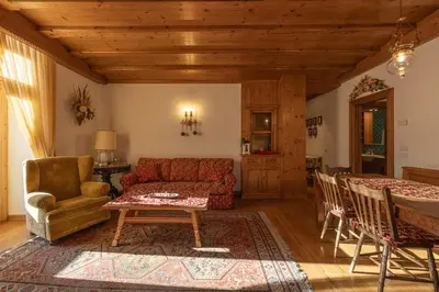 a living room with a red couch and a table at Casa Ciclamino, direttamente sul Corso di Cortina dAmpezzo in Cortina dʼAmpezzo