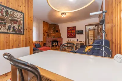 a dining room and living room with a table and chairs at Casa Ciadenac in Soraga
