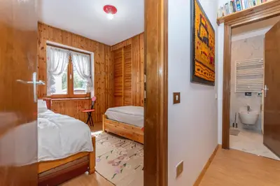 a bedroom with a bed and a bathroom at Casa Ciadenac in Soraga