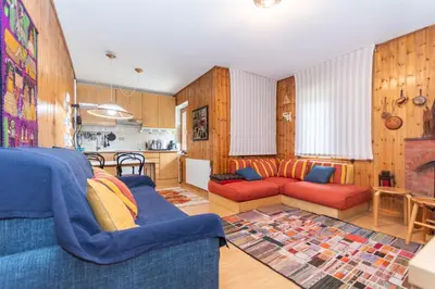 a living room with two couches and a kitchen at Casa Ciadenac in Soraga