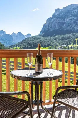 a bottle of wine sitting on a table with two glasses at Apartements Precalalt in La Villa