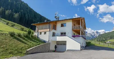 a house on a hill with a man standing in front of it at Apartements Precalalt in La Villa