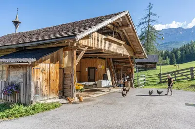a wooden barn with people standing outside of it at Apartements Precalalt in La Villa