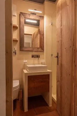 a bathroom with a sink and a toilet and a mirror at Casa Bucaneve, con terrazza panoramica sulle Dolomiti in Cortina dʼAmpezzo