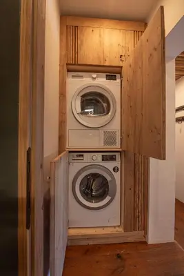 a washer and dryer in a small room at Casa Bucaneve, con terrazza panoramica sulle Dolomiti in Cortina dʼAmpezzo