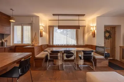 a kitchen with a dining room table and chairs at Casa Bucaneve, con terrazza panoramica sulle Dolomiti in Cortina dʼAmpezzo