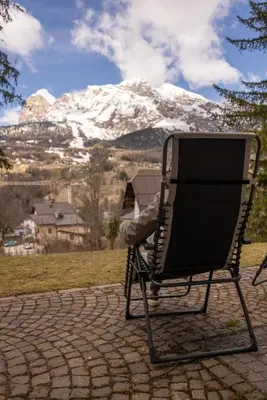 a chair sitting on a patio with a snow covered mountain at Casa Bucaneve, con terrazza panoramica sulle Dolomiti in Cortina dʼAmpezzo