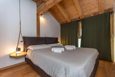 a bedroom with a large bed with two towels on it at El Maso - Arabba in Livinallongo del Col di Lana