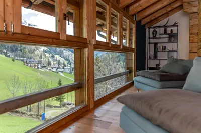 a living room with large windows and a couch at El Maso - Arabba in Livinallongo del Col di Lana