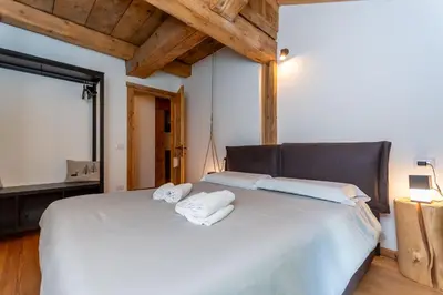 a bedroom with a white bed with towels on it at El Maso - Arabba in Livinallongo del Col di Lana