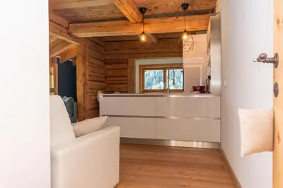 a living room with a white couch and wooden ceilings at El Maso - Arabba in Livinallongo del Col di Lana