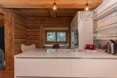 a kitchen with a white counter top and wooden walls at El Maso - Arabba in Livinallongo del Col di Lana