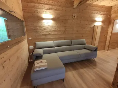 a living room with a couch and a table at Tabià del Belli in Livinallongo del Col di Lana