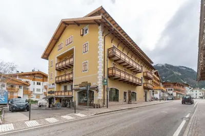 a yellow building on the side of a street at Casa Bristol in Pozza di Fassa