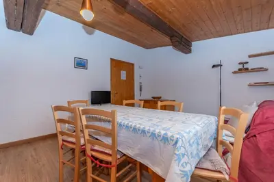 a dining room with a table and chairs in a room at Casa Bristol in Pozza di Fassa