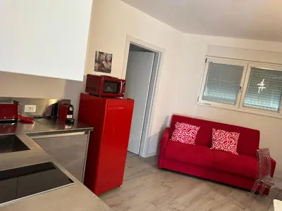 a red couch in a kitchen with a red refrigerator at Ida s home free WiFi AC in Bolzano