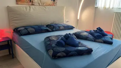 a bed with blue pillows on top of it at Ida s home free WiFi AC in Bolzano