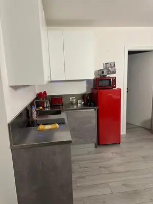 a kitchen with a red refrigerator and white cabinets at Ida s home free WiFi AC in Bolzano