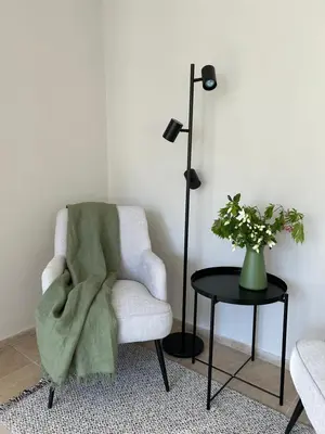 a room with a chair and a table with a lamp at Garden Apartment Villa Corazza in Tirolo