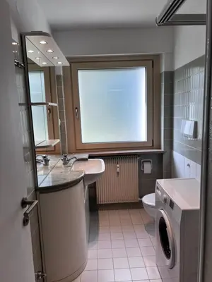 a bathroom with a sink and a toilet and a window at Garden Apartment Villa Corazza in Tirolo
