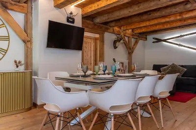 a dining room with a table and white chairs at AE 1793 - Arabba in Livinallongo del Col di Lana