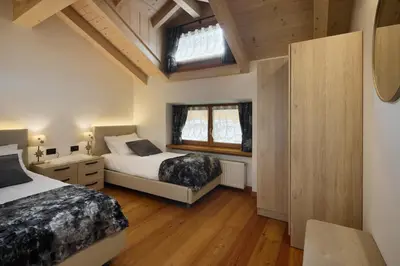a bedroom with two beds and a window at Apartment Alpen Dolomites in Selva di Cadore